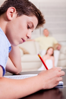 Young Boy Writing In Notebook by photostock